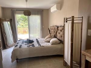 a bedroom with a bed and a large window at Galibier Villa in La Celle-sous-Gouzon