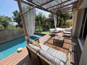 a wooden deck with chairs and a swimming pool at Galibier Villa in La Celle-sous-Gouzon