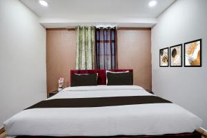 a bedroom with a large bed and a window at Hotel O 3 Bros in Sohāna