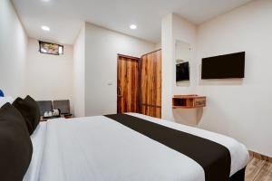 a bedroom with a bed and a television on the wall at Hotel O 3 Bros in Sohāna