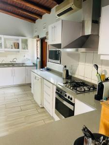 a kitchen with white cabinets and a stove top oven at 4 Bedroom Beach House on 4th Ave in Umdloti