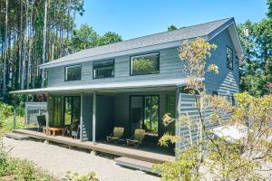 une maison bleue avec des portes en verre et une terrasse couverte dans l'établissement いすみ市の自然の中の別荘B棟-IsumiB, à Ichigaya