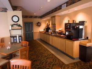 un restaurante con cocina con barra y mesa en Country Inn & Suites by Radisson, Dundee, MI, en Dundee