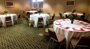 una habitación con mesas y sillas con manteles blancos en Country Inn & Suites by Radisson, Dundee, MI, en Dundee
