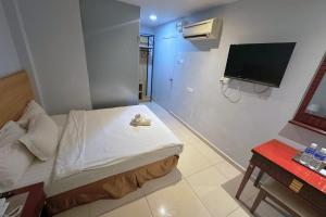 a small room with a bed and a flat screen tv at Hotel AL Amin in Kuala Lumpur