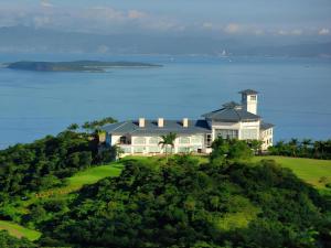 a house on top of a hill next to the ocean at The Century Seaview Hotel in O-kung