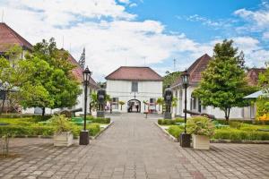 a cobblestone street in a town with houses and trees at Indoluxe Hotel Jogjakarta in Kejayan
