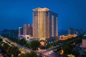 a large building in a city at night at Inzone Garlnd Hotel Zhangqiu in Zhangqiu