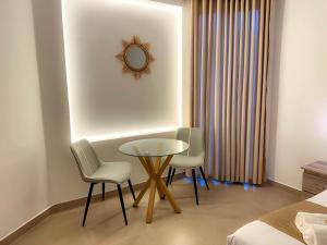 a room with a table and two chairs and a mirror at La Costa Hotel in Katunayake