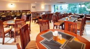 a restaurant with tables and chairs in a room at Barcelona Hotel Nha Trang in Nha Trang