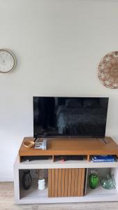 a entertainment center with a tv on top of it at Studio cosy aux portes de Geneve in Ferney-Voltaire +4 photos