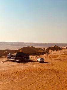 a white car parked in the middle of a desert at Desert Vibes Camp in Bidiyah +36 photos