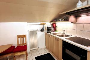 een kleine keuken met een spoelbak en een aanrecht bij Casa Foresta in Maggia