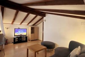 een woonkamer met een bank en een tv bij Casa Foresta in Maggia