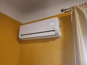 eine Klimaanlage an einer Wand neben einem Vorhang in der Unterkunft Unique Mailo cottage in Riga