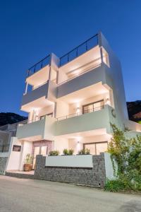 a large white building with some plants in front of it at Naiades Guest House in Sálakos