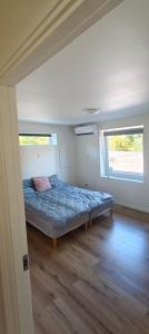 a bedroom with a bed in a room with two windows at Værelser i Ølst, Randers SV in Randers