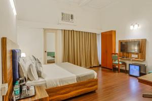 asar CP Outer Circle by Orion Hotels في نيودلهي: غرفة فندق مع سرير ومكتب