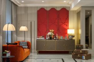 a living room with an orange couch and a red wall at La Clef Tour Eiffel Paris by The Crest Collection in Paris