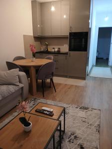 a living room with a table and a kitchen at Aprtman SALE in Vrnjačka Banja