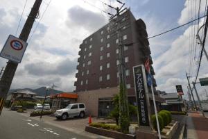 a building on a street with a van parked in front at APA Hotel Nishimaizuruekimae in Kuradani