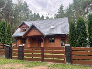 a wooden house with a fence in front of it at Forest Home Dębowa 18 in Łuka +34 photos