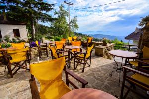 un grupo de mesas y sillas en un patio en Varnevo Guesthouse en Ano Trikala