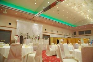 a banquet hall with white tables and white chairs at AKISAWA HOTEL in Sukumo