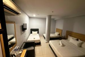 クアラルンプールにあるHotel AL Aminのベッド2台とシンクが備わる小さな客室です。