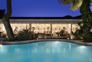 a swimming pool in front of a restaurant at night at Hotel Meridiana in Paestum