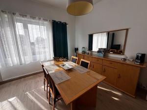 a dining room with a table and a mirror at Le Cottage Malouin in Dunkerque
