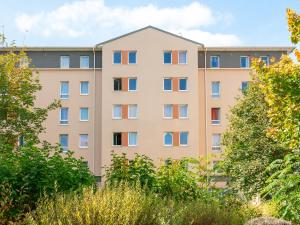 an apartment building with colorful windows at Séjours & Affaires Caen Le Clos Beaumois in Caen