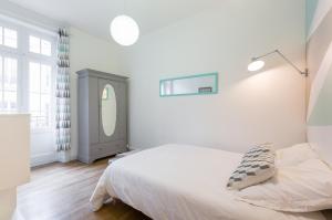 a white bedroom with a bed and a mirror at Arlequin by Cocoonr in Rennes