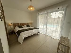 a bedroom with a bed and a large window at Les Villas de Fiori Di Cala Rossa in Lecci +125 photos
