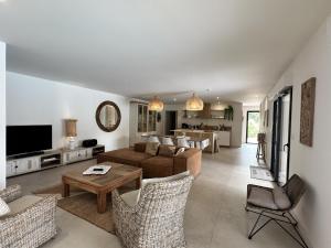 a living room with a couch and a table at Les Villas de Fiori Di Cala Rossa in Lecci