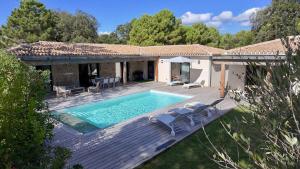 a villa with a swimming pool and a wooden deck at Les Villas de Fiori Di Cala Rossa in Lecci