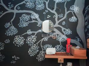 a bathroom with a mirror and a tree mural at The Happy 8 Retreat @ Kuala Sepetang in Kampung Sepetang