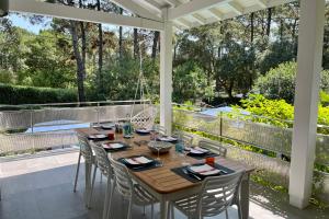 a wooden table and chairs on a patio with a view at Villa Hortensia - Welkeys in Soorts-Hossegor