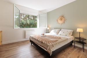 a bedroom with a large bed and a window at Villa Hortensia - Welkeys in Soorts-Hossegor +26 photos