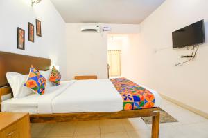 カンドリムにあるFabHotel Benz Destination - 700m Candolim Beachのベッドと薄型テレビのある寝室