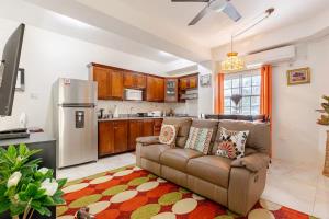 a living room with a couch and a kitchen at Seacastles by the beach/pool in Montego Bay