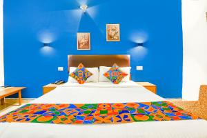 カンドリムにあるFabHotel Benz Destination - 700m Candolim Beachの青い壁のベッドルーム1室