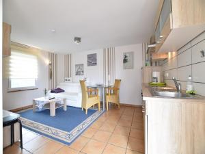 a kitchen and living room with a couch and a table at Boutique Bungalow in Insel Poel with terrace in Insel Poel