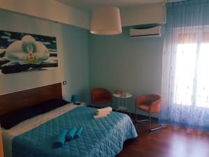 una camera da letto con un letto con scarpe blu sopra di Nonna Lucia a San Giorgio Ionico