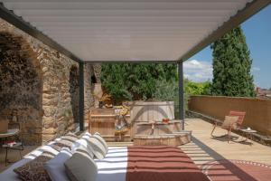 a covered patio with a bed and a fireplace at MiHotel - La Maison Rose in Lyon