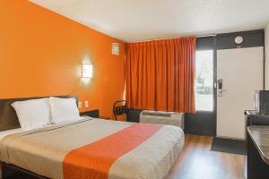 a hotel room with a bed with an orange wall at Motel 6-Little Rock, AR - West in Little Rock +49 photos