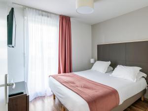 a bedroom with a large bed and a large window at Séjours & Affaires Caen Le Clos Beaumois in Caen +26 photos