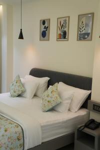 a bed with four pillows on it in a bedroom at Hotel ARCHWAY By SOMU'S PRIMS in Jaipur