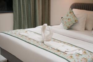 a pair of white shoes on a bed at Hotel ARCHWAY By SOMU'S PRIMS in Jaipur +9 photos