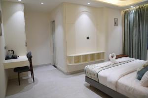 a bedroom with a bed and a desk and a table at Hotel ARCHWAY By SOMU'S PRIMS in Jaipur